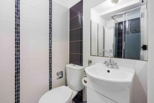 a white bathroom with a toilet and a sink at Luxe City in Rijeka