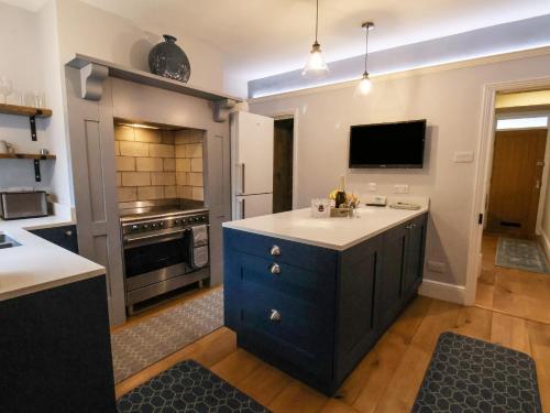 a kitchen with a blue island in the middle at Bumblebee Cottage in Beverley