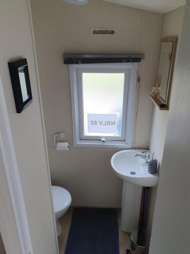 a bathroom with a sink and a toilet and a window at Billing Aquadrome in Great Billing