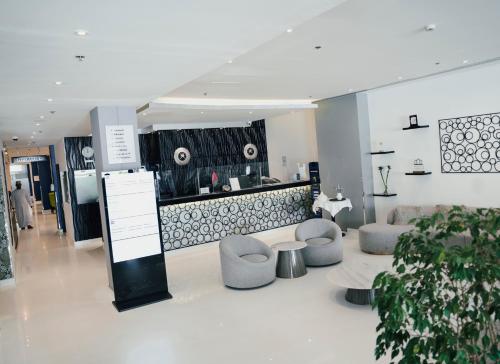 a lobby with couches and chairs and a counter at Best Western Premier Muscat in Muscat