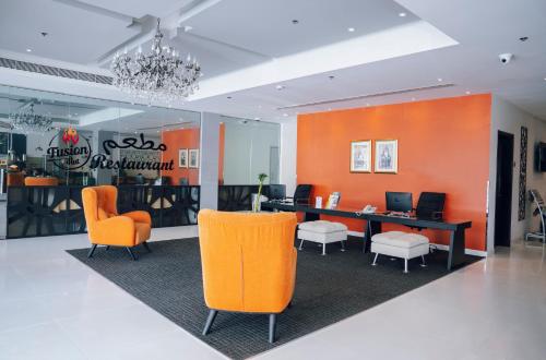 Best Western Premier Muscat في مسقط: مكتب فيه كراسي برتقالية وبيضاء ومكتب