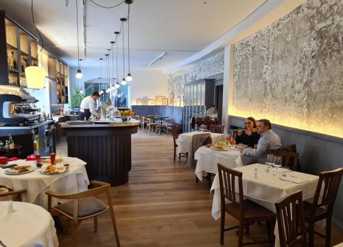 a restaurant with white tables and people sitting at tables at Il Sole in Bergamo