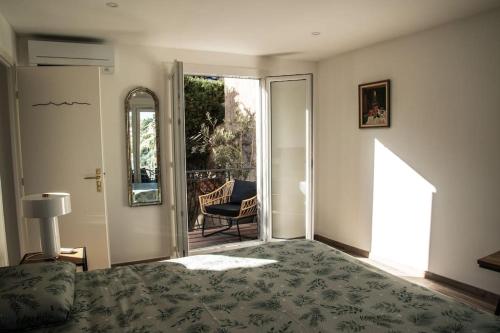 - une chambre avec un lit et une porte donnant sur une terrasse dans l'établissement Les Balcons du Roucas Blanc, à Marseille