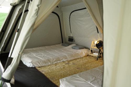 ein kleines Schlafzimmer mit einem Bett in einem Zelt in der Unterkunft iGo Glamz 爱狗露营 Pet Friendly Glamping in Genting Highlands
