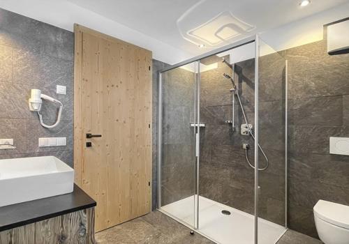 een badkamer met een douche, een toilet en een wastafel bij Apartment Pichlerhof in San Lorenzo di Sebato