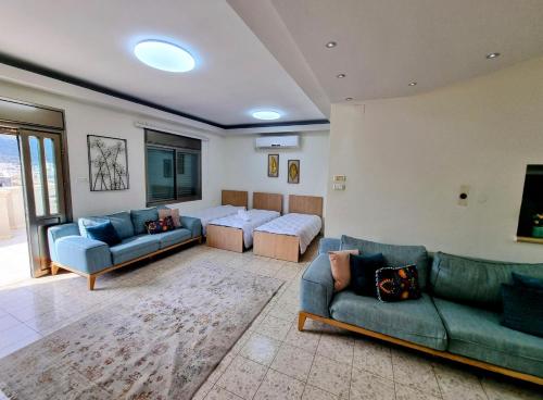 een woonkamer met 2 banken en een bank bij Your Home in Deir Ḥannā