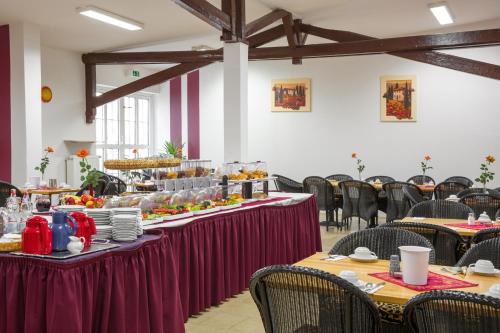 een eetkamer met tafels en stoelen met eten erop bij Hotel Alte Fabrik in Mettmann