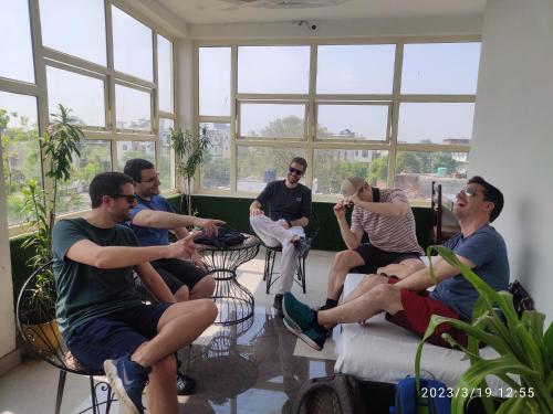 a group of people sitting in a room with windows at Max Guest House in Agra