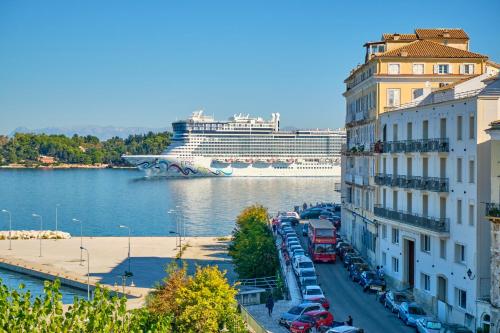 a cruise ship in the water next to a building at Anesis Apartment Corfu Town in Corfu Town