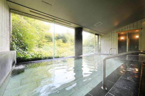 a bathroom with a large pool of water at Yutorelo Atami in Atami