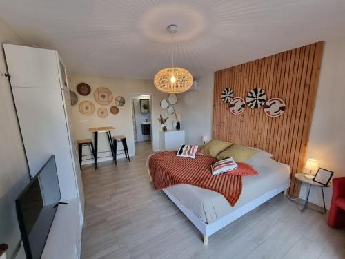 1 dormitorio con 1 cama y TV de pantalla plana en Lodge Cosy tout confort Lodge des Oliviers, en Ganges
