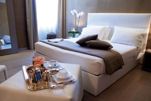 a hotel room with a bed and a table with a tray of food at Hotel San Rocco in Orta San Giulio