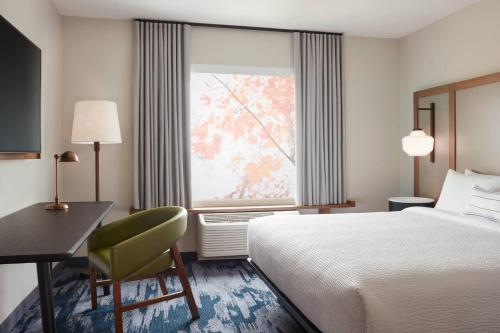 a hotel room with a bed and a desk and a window at Fairfield by Marriott Inn & Suites Winters Davis in Winters