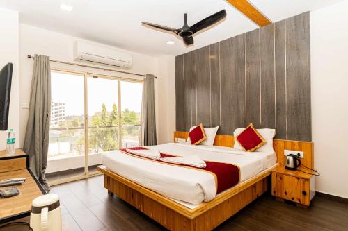 a bedroom with a large bed and a window at Hotel Aalia in Thanjāvūr