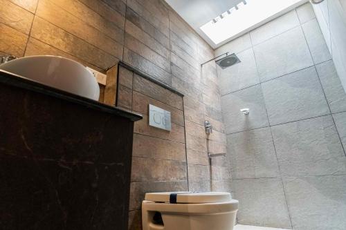 a bathroom with a shower with a toilet and a sink at Hotel Aalia in Thanjāvūr