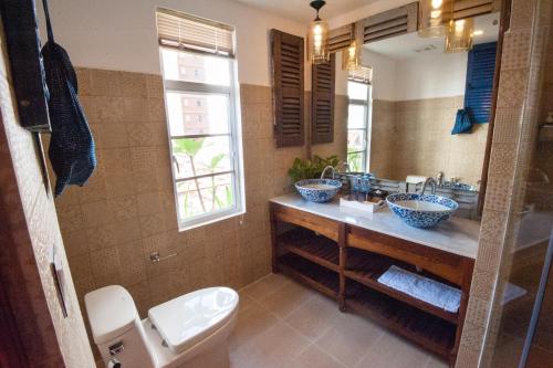 a bathroom with two sinks and a toilet at Khmer Surin Boutique Guesthouse in Phnom Penh