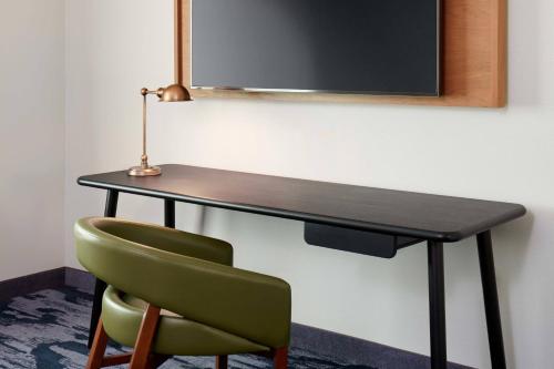 a black desk with a green chair and a lamp at Fairfield Inn & Suites by Marriott Morristown in Morristown