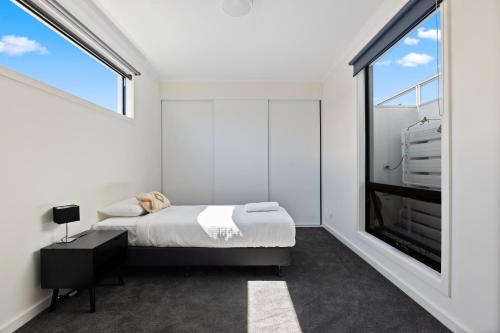 - une chambre avec un lit et une grande fenêtre dans l'établissement Swainson on College, à Port Adelaide