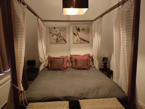 a bedroom with a canopy bed with two pillows at The Manhattan Luxury suite in Jumet