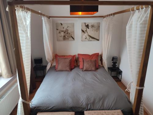 a bedroom with a canopy bed with red pillows at The Manhattan Luxury suite in Jumet