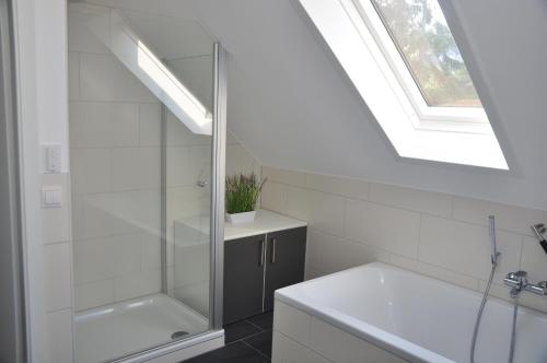 a bathroom with a shower and a sink and a window at Am Alten Leuchtfeuer - a67400 in Eckernförde