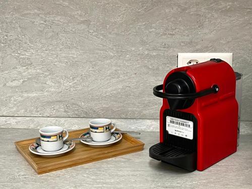 a red coffee maker and two cups on a tray at Bilocale con terrazzi Via Antonio Riva 3 by LR in Lugano