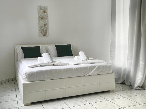 uma cama branca com lençóis brancos e almofadas em Bilocale con terrazzi Via Antonio Riva 3 by LR em Lugano