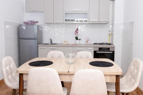 kuchnia z drewnianym stołem i białymi szafkami w obiekcie Millennium Apartment w mieście Bačka Palanka