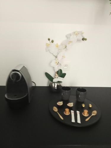 a black table with a plate of food and a speaker at The Manhattan Luxury suite in Jumet