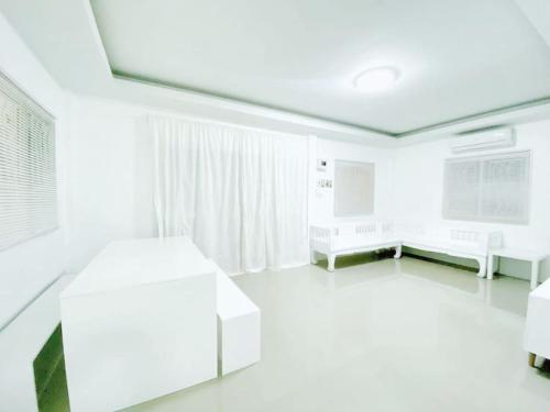 a white room with white furniture and a window at Pool Villa Sattahip White House in Sattahip