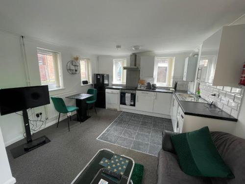 ein Wohnzimmer mit einem Sofa und einer Küche in der Unterkunft 1 Bed @ Factory Quater - Chard St in Nottingham