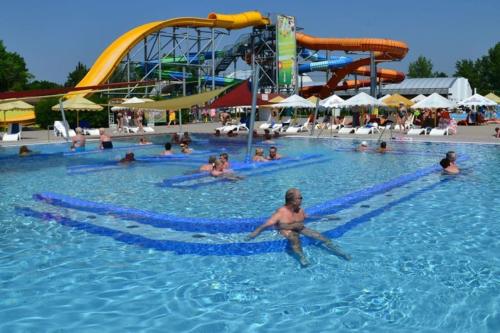 a group of people swimming in a pool at a water park at Apartmán Kristína in Štúrovo