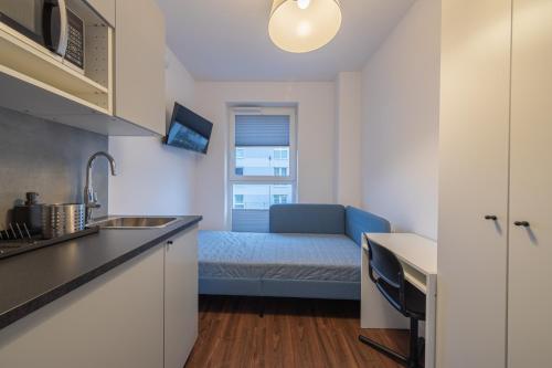 eine Küche mit einem Sofa in einem kleinen Zimmer in der Unterkunft TinyRooms in Kattowitz