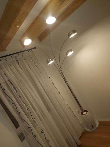 a bathroom with a shower curtain and lights on the ceiling at VitaminSea - Lovran in Lovran