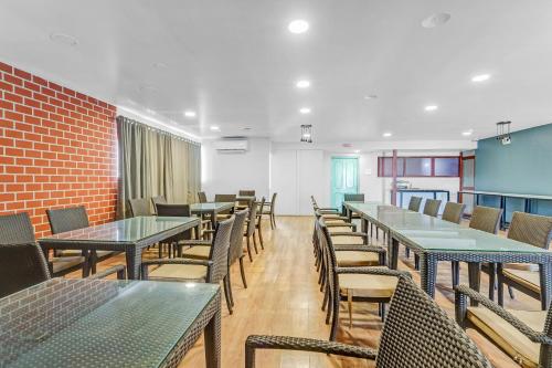 a dining room with tables and chairs and a brick wall at UPAR Hotels Indiranagar in Bengaluru