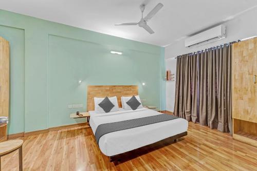 a bedroom with a bed and a ceiling fan at Upar Hotels Indiranagar in Bangalore