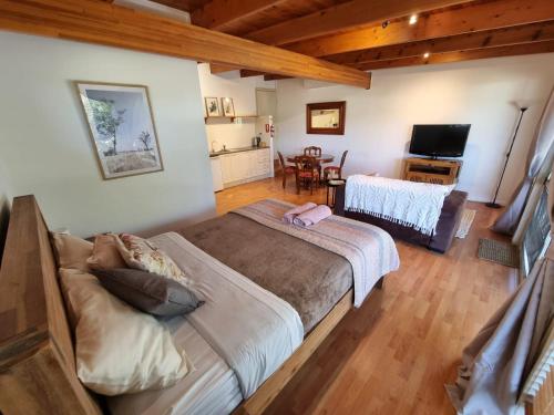 a bedroom with a large bed and a living room at Clandulla Cottages & Farmstay in Boyland