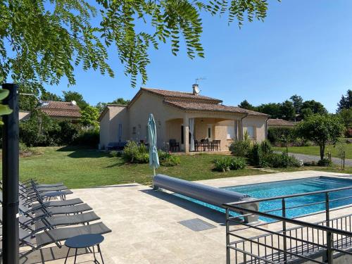 une piscine avec des chaises et une maison dans l'établissement La Grand Vigne - Maison avec piscine privée, à Saint-Genest-de-Bauzon