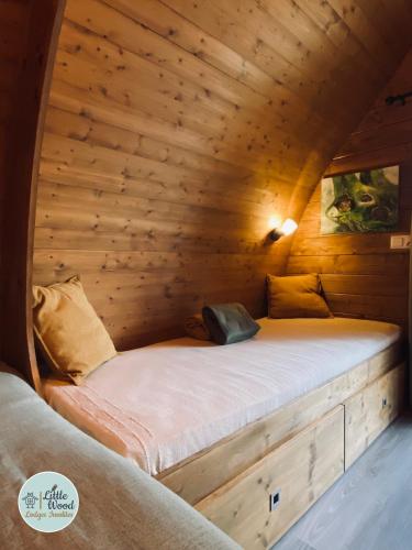 a bed inside of a wooden cabin with a mattress at Little Wood Lodges in Bailly-aux-Forges