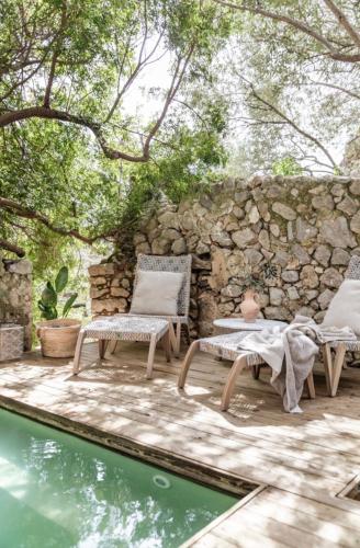a patio with two chairs and a swimming pool at Ca'n Beneït in Binibona