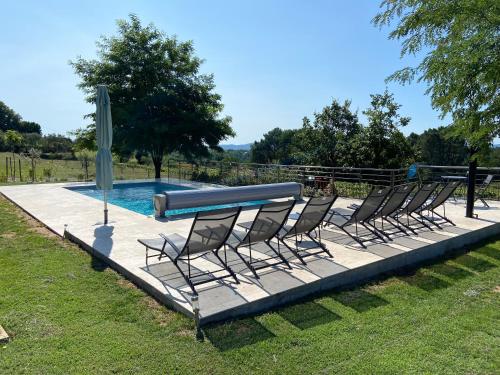 un groupe de chaises assises à côté d'une piscine dans l'établissement La Grand Vigne - Maison avec piscine privée, à Saint-Genest-de-Bauzon