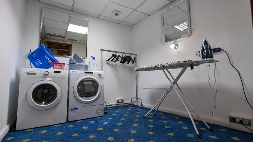 a laundry room with a washing machine and a desk at Hotel Martini in Verona