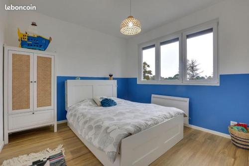 1 dormitorio con paredes azules y 1 cama blanca en VILLA LUNA - 9 couchages - terrain pétanque - wifi - netflix, en Capbreton