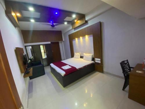 a bedroom with a bed and a tv in it at Redbell Suites Calicut in Kozhikode
