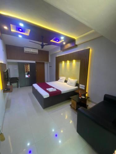 une chambre d'hôtel avec un lit et un canapé dans l'établissement Redbell Suites Calicut, à Kozhikode