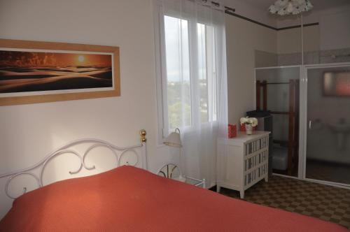 een slaapkamer met een rood bed en een raam bij 2 pièces calme et fonctionnel in Cagnes-sur-Mer