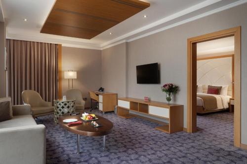 a living room with a room with a couch and a bed at Ramada by Wyndham Erbil Gulan Street in Erbil