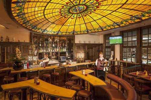 a restaurant with a stained glass ceiling and a bar at Dorint Hotel Potsdam in Potsdam
