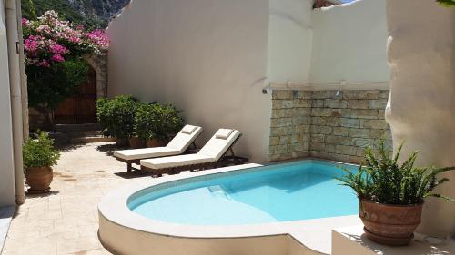a swimming pool in a patio with two chairs at Casa Sofia in Spílion