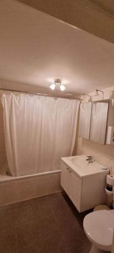 een badkamer met een wit douchegordijn en een wastafel bij Alliance Hotel Ieper Centrum in Ieper